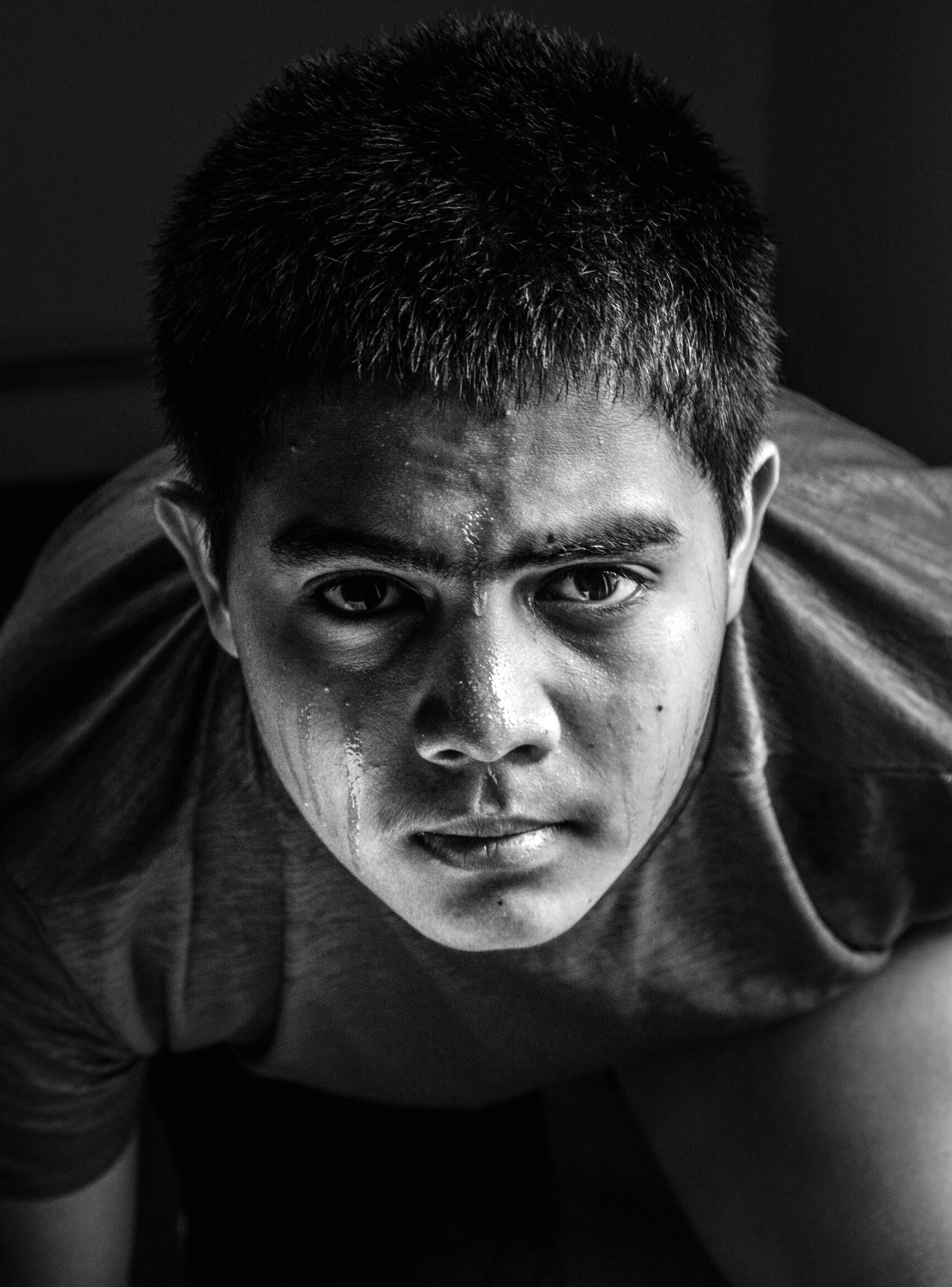 Photograph of Rahul with sweat/water on this face, staring at the camera as if for a sports ad